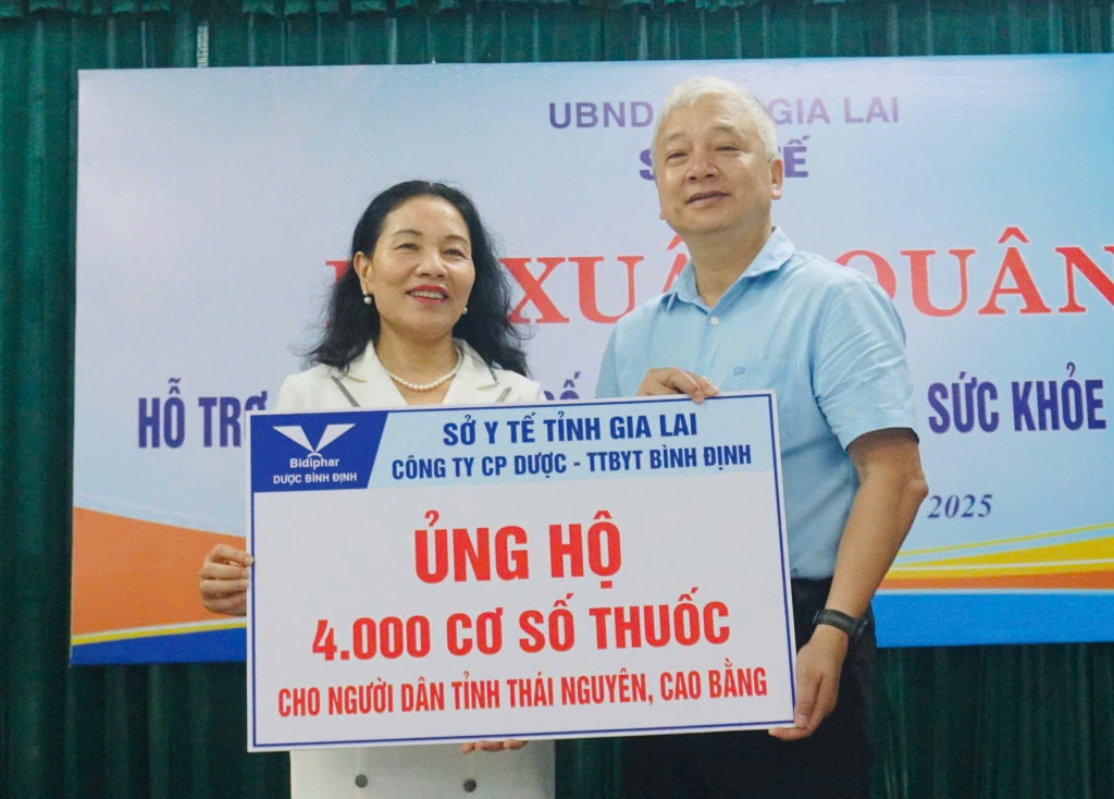 Đại diện Bidiphar trao bảng tượng trưng ủng hộ cơ số thuốc cho ông Lê Quang Hùng tại lễ xuất quân (Ảnh: Thảo Khuy)