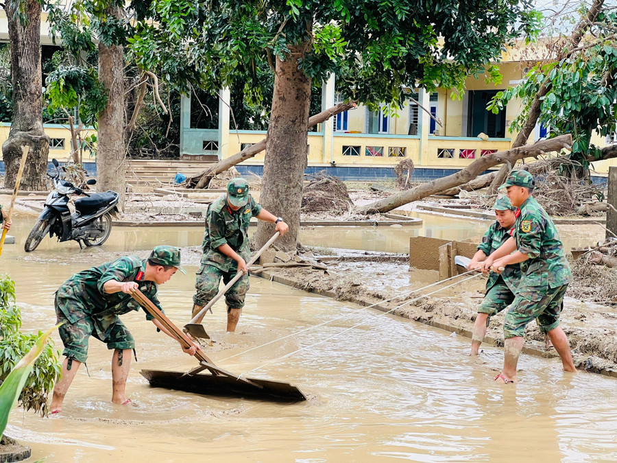 Lực lượng quân đội hỗ trợ dọn vệ sinh khuôn viên Bệnh viện Tâm thần Quy Nhơn (phường Quy Nhơn Bắc) do ảnh hưởng của lũ lụt (Ảnh: Minh Nhật)