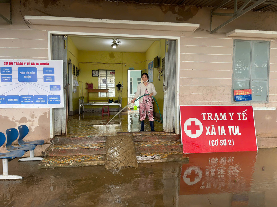 Cán bộ, nhân viên Trạm Y tế xã Ia Tul cơ sở 2 dọn dẹp bùn đất sau lũ (Ảnh: Vũ Chi)