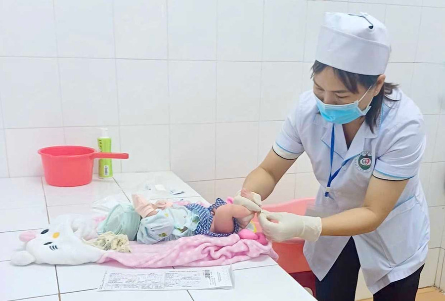 Nhân viên y tế lấy máu gót chân trẻ sơ sinh tại TTYT Đak Đoa