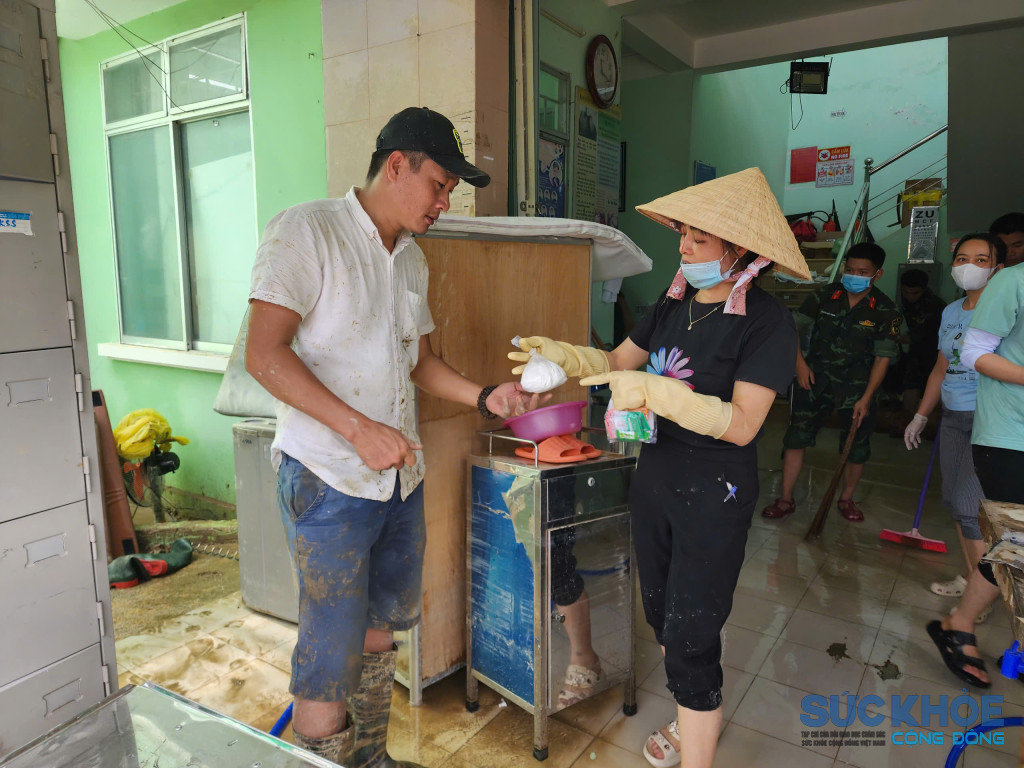 Chị Nguyễn Thị Kim Cúc phụ trách trạm y tế Vĩnh Phương phát thuốc khử trùng cho người dân (Ảnh: Thanh Huy)